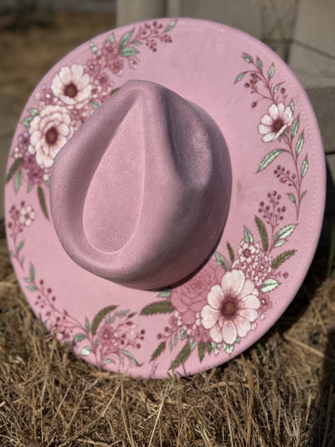 Blush pink hat shown top-down with daisies and vines across the brim